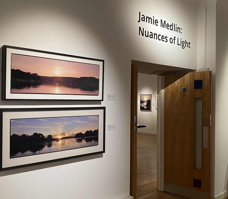 Entrance to the Jamie Medlin exhibition with panoramic seascape paintings either side