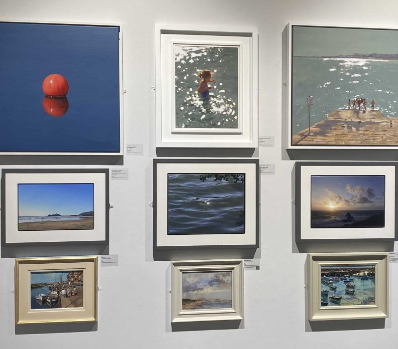 Framed Cornish seascape prints with red buoy studies on a gallery wall